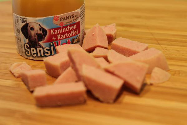 einzelne Kaninchen Trainingswurst in Stücke geschnitten auf einem Holzbrett